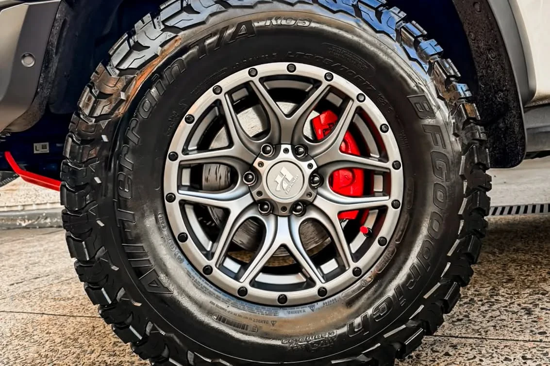 Silver alloy wheel and chunky tyre with a red brake calliper