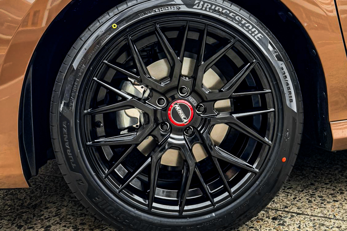 Close-up of a black Hussla wheel on a copper-coloured Toyota Camry