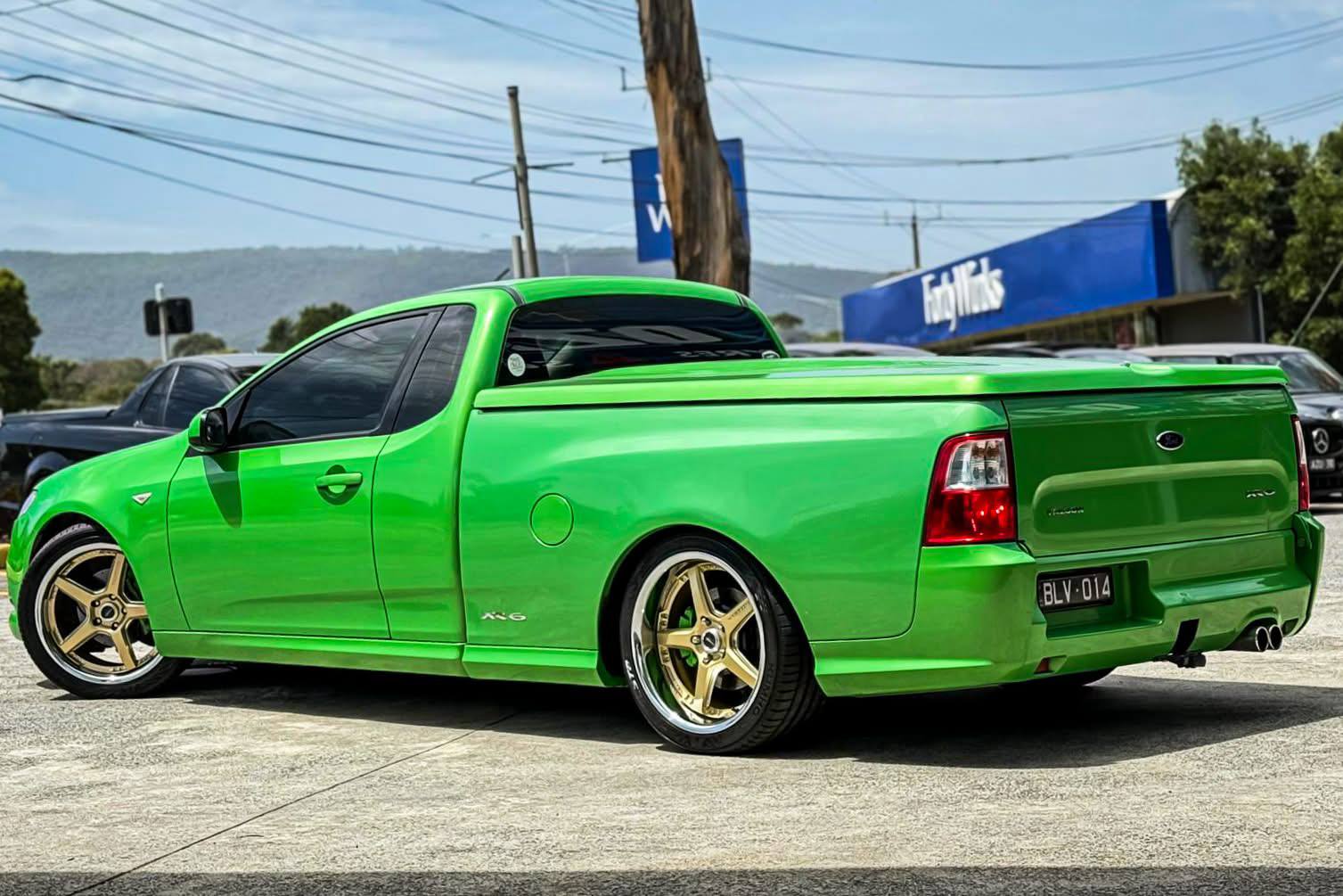 Bright green Ford ute with gold alloy wheels