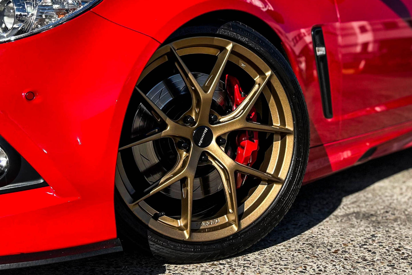 Original Rhino photo of a red car with bronze alloy wheels